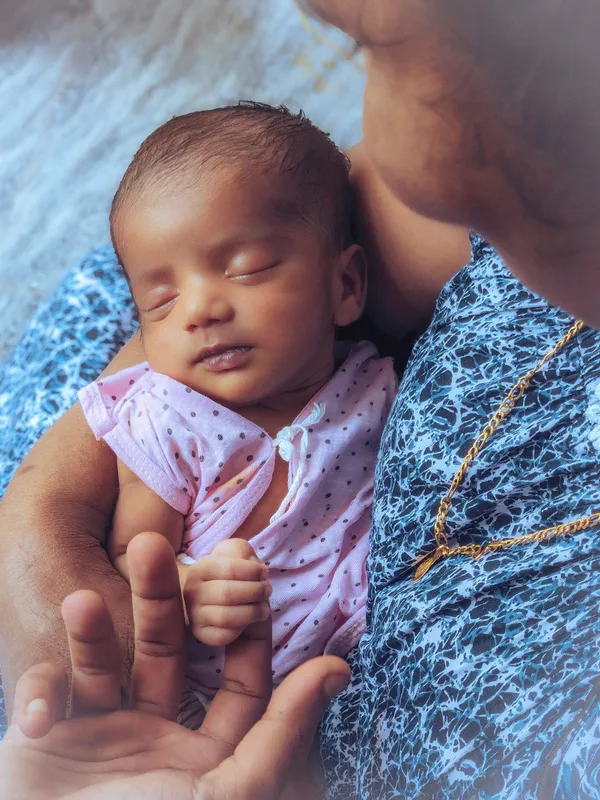 Ein Baby liegt geborgen auf dem Arm einer Bezugsperson.