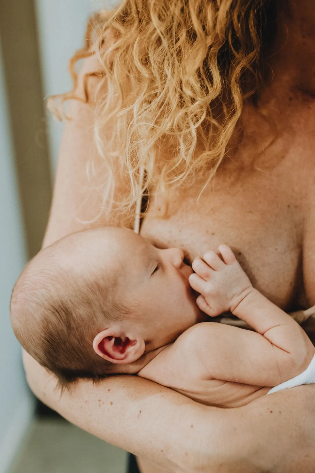 Eine Mutter stillt ihr Baby und schaut es an.